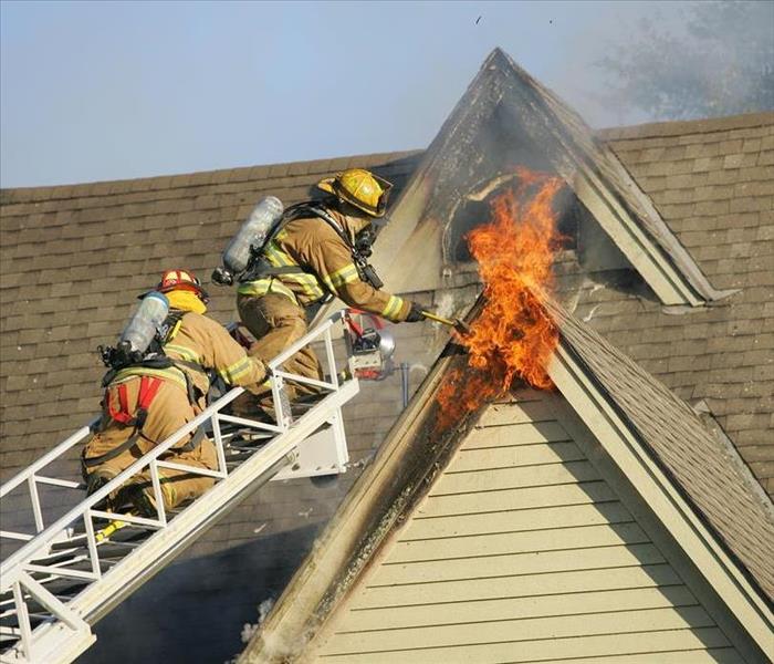 Fireman climbing ladder to extinguish 2nd floor fire