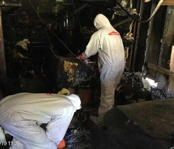 Picture of our technicians in their PPE cleaning a garage from fire damage