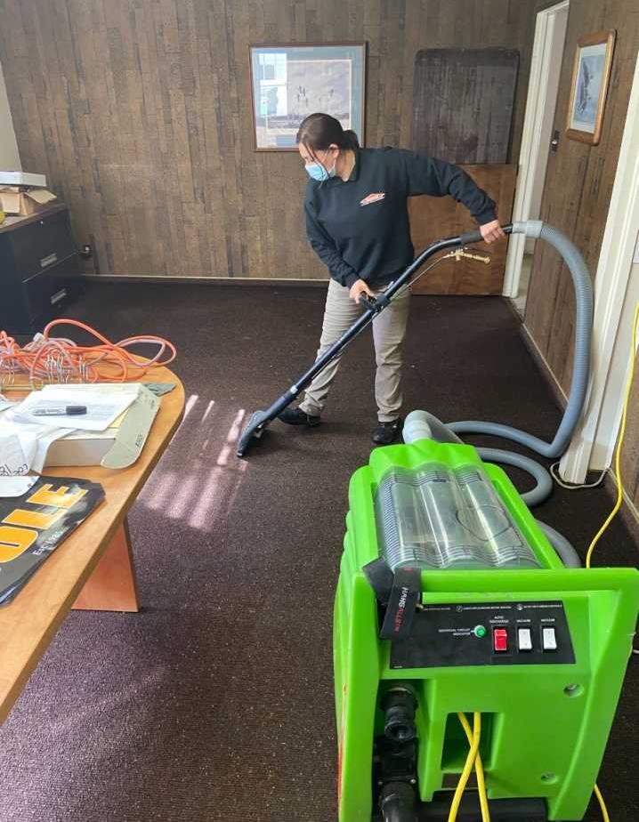 A picture of our technician extracting water from an office carpet