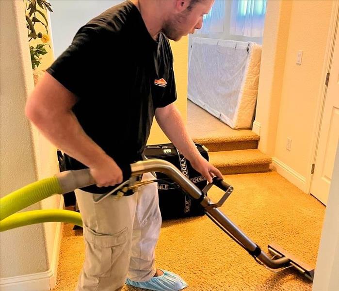 Picture of our technician extracting water from carpet flooring