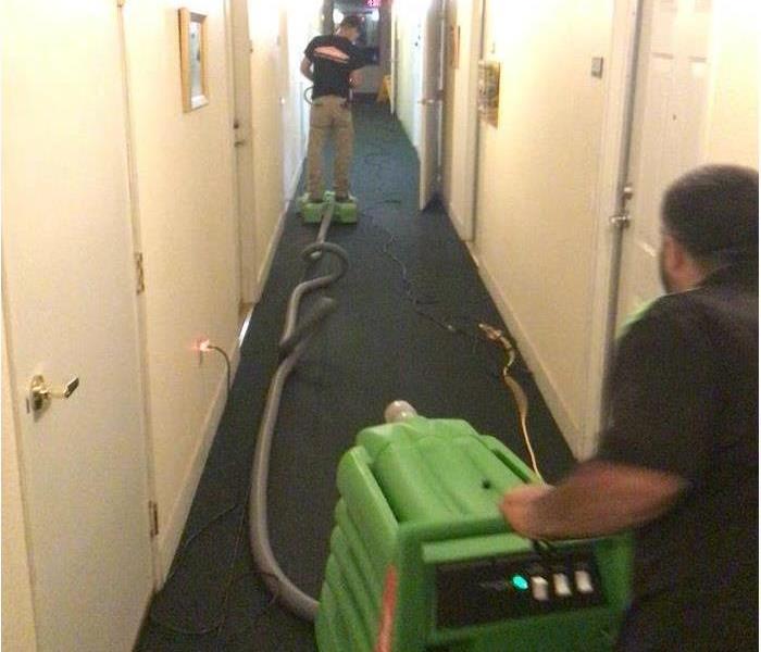 A picture of our technician extracting water from an apartment building carpet