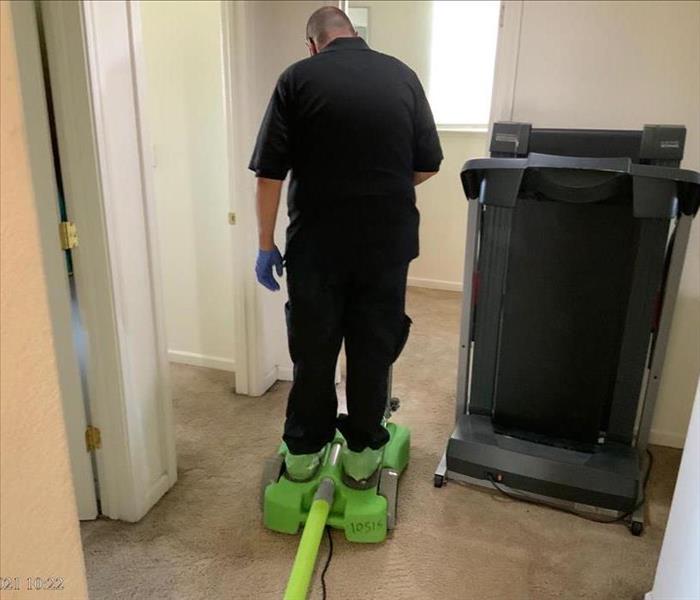 Technician extracting water from carpet